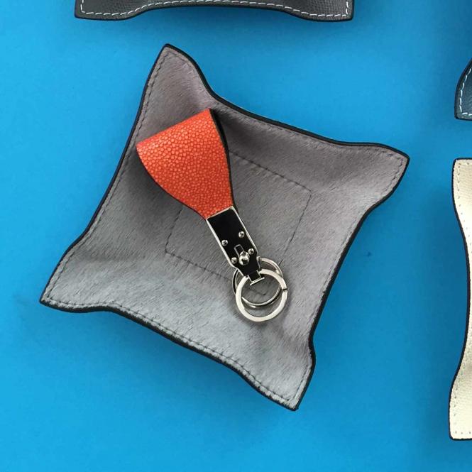Giobagnara Travel Valet Jack quadratisch S aus Fellleder grau - darauf liegt ein cognac-farbiger Schlüsselanhänger aus Leder Lederablage Jack quadratisch S, Fellleder grau,
